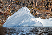 Skjoldungen Fjord. Large iceberg in scenic fjord surrounded by snow-capped mountains, Southeast coast, Greenland