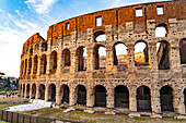 The ancient Roman Colosseum or Flavian Amphitheater with golden sunset light in Rome, Italy.