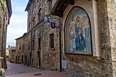 Medieval architecture on Via Palestro near the Arch of Becci in the medieval city of San Gimignano, Italy.