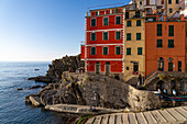 A colorful building overlooking the harbor and Lingurian Sea in Riomaggiore, Cinque Terre, Italy.