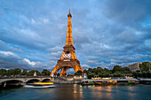 Scenic panorama of Eiffel Tower, Seine River, and pont d'lena in Paris, France; with a cruise passing by ferry