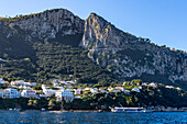 View of the port of Marina Grande on the island of Capri, Italy. Viewed from the Bay of Naples. A high-speed passenger ferry is anchored off shore.