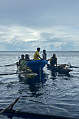 Residents of New Hanover island in their traditional dugout canoes, New Ireland province, Papua New Guinea