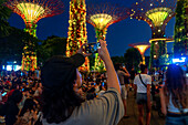 Light and music show in Gardens by the Bay park Supertrees elevated walkway skyway between colourful lit Super Trees, Gardens by the Bay, Singapore