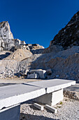 A Carrara marble bench for sitting on during the quarry tour in Fantiscritti. Carrara, Italy. A quarry is behind.