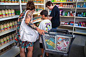 Poor and vulnerable families collecting donated products in the supermarket Rebost Solidari de Gracia, Gracia neighborhood, Barcelona, Spain, Europe. The Rebost Solidari de Gracia is a distributor entity of the Food Bank in its Sec, SERMA (fresh fruit and vegetables), cold chain (frozen and refrigerated products) and FEGA (products received from the EU) programs. An efficient management of all the food surpluses generated by the neighborhood (markets, supermarkets, shops, companies, restaurants, school canteens and others) is an important enough objective in itself, both for its use in the nei