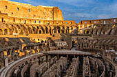 Interior of the Roman Colosseum or Flavian Amphitheater with golden sunset light in Rome, Italy. The tunnels under the floor of the arena were called hypogeum.