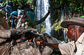 Haiti Voodoo Festival in Saut d'Eau, in Saut d'Eau, Ville Bonheur, Haiti. Thousands of both Vodou and Catholic followers gathered under the Saut d'Eau waterfall in Haiti. The pilgrimage, made by Voodou practitioners and Catholics alike, originated with the sighting of the likeness of the Virgin Mary on a palm leaf close to the falls half a century ago. Catholism and Voodou practices are forever intertwined in its Haitian form. The appearance of a rainbow beneath the falls is said indicate that Danbala - the great lord of the waterfall - and Ayida Wedo - the rainbow - are making love. Fertility