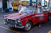 A taxi driver with his customized 1960s vintage Fiat 1500 cabriolet taxi in the town of Capri, Italy.