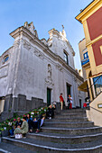 Tourists on the steps of the Church of Santo Stefano in the town of Capri, Italy.