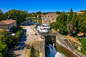 Aerial view of the triple écluse des moulins de Trèbes look aux portes du Minervois. Canal du Midi at village of Puichéric Carcassone Aude South of France southern waterway waterways holidaymakers queue for a boat trip on the river, France, Europe