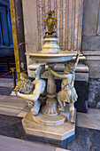 Sculpture of a devil cowering under a stoup of Holy Water in the Basilica of St. Paul Outside the Walls, Rome, Italy.