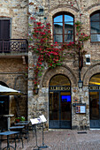 A restaurant in a medieval building in the Piazza della Cisterna in the walled city of San Gimignano, Italy.