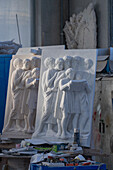 A cast resin model and finished bas relief marble sculpture in a marble carving studio in Carrara, Italy.