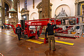 Workers lay down pads to protect the floor of the Basilica of Santa Croce from maintance machinery. Florence, Italy.