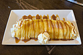 A sweet crepe topped with whipped cream, chocolate and caramel sauce.