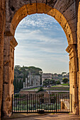 View of the Roman Forum through an arch of the ancient Colosseum in Rome, Italy.