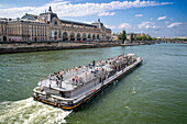 Passenger touristic cruise ship in the Seine river is moored to the pier near Louvre museum