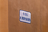 A ceramic street sign for Via Santa Reparata on the painted stucco wall of a building in historic Florence, Italy.