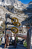 Vintage wheel & pulley system for cutting marble with diamond-coated wire. Fantiscritti Quarry Museum, Carrara, Italy. The quarries are visible on the mountain behind.