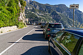 Cars parked along the narrow Amalfi Coast road near Positano on the Sorrento Peninsula in italy.