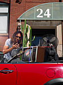 Mann packt Auto voll mit Habseligkeiten