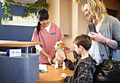Boy and Woman with Dog at Veterinarian's Office