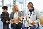 Boy and Woman with Dog at Veterinarian's Office