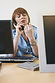Frau plaudert am Telefon bei der Arbeit