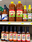 Supermarktregal mit scharfen Soßen auf Paprikabasis
