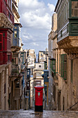 Street scene of alley with traditional homes, colourful balconies and a red post box, Valletta, Malta