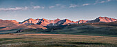 Panorama of sunset over snow-capped mountain range in the Song Kol lake area of Kyrgyzstan