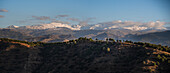 Sunset over hilly landscape in front of the Snowy Sierra Nevada, Albaicin, Granada, Andalucia, Spain