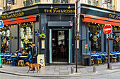 Young man with dog in front of bar The Frog and Rosbif on Rue Saint-Denis, Paris, France