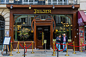 Couple outside restaurant Bouillon Julien on Rue Saint-Denis, Paris, France