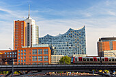 U-Bahn-Zug auf Gleisen mit Elbephilharmonie im Hintergrund, Hamburg, Deutschland, Europa