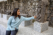 Student berührt eine Statue in der Festung Daulatabad, Maharashtra, Indien