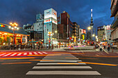 View of colourful shops and buildings with Tokyo Skytree visible in background at night, Asakusa, Taito City, Tokyo, Honshu, Japan