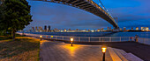 Blick auf die Regenbogenbrücke und Koto City im Hintergrund in der Abenddämmerung, Minato City, Tokio, Honshu, Japan