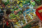 Elevated view of woman inspecting colourful fresh vegetables on stall in Omicho Market, Kanazawa City, Ishikawa Prefecture, Honshu, Japan