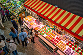 Elevated view of colourful fresh fruit stall and people in Omicho Market, Kanazawa City, Ishikawa Prefecture, Honshu, Japan