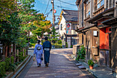 Einheimisches Paar im Kimono und traditionelle Gebäude aus dunklem Holz im Bezirk Higashi Chaya, Stadt Kanazawa, Präfektur Ishikawa, Honshu, Japan