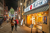 View of street scene and Japanese restaurant at night, Hiroshima, Honshu, Japan