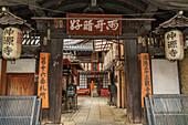 View of temple entrance on Shijo Dori during daytime in Nakagyo Ward, Nabeyacho, Kyoto, Honshu, Japan