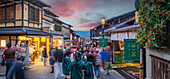 View of busy street and traditional wooden houses and shops in Gion, Kyoto Geisha District, Kyoto, Honshu, Japan