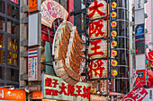 View of colourful facades of restaurants in Dotonbori, vibrant entertainment district near the river, Osaka, Honshu, Japan