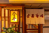 Blick auf den hölzernen Eingang eines Restaurants in Dotonbori, einem pulsierenden Vergnügungsviertel in der Nähe des Flusses, Osaka, Honshu, Japan