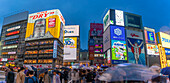 Blick auf das Glico-Schild in Dotonbori, einem pulsierenden Vergnügungsviertel in der Nähe des Flusses, in der Abenddämmerung, Osaka, Honshu, Japan