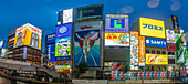 Blick auf das Glico-Schild in Dotonbori, einem pulsierenden Vergnügungsviertel in der Nähe des Flusses, in der Abenddämmerung, Osaka, Honshu, Japan