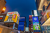 View of colourful adverts in Dotonbori, vibrant entertainment district near the river at dusk, Osaka, Honshu, Japan